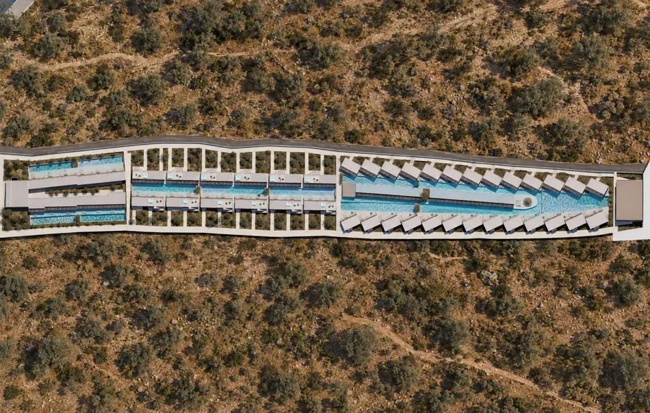Top-down aerial view of the resort's pool winding between the rooms